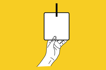 Hand holding blank white sign on yellow background