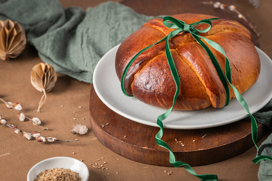 Portuguese traditional Easter cake Folar without eggs on easter table with a green ribbon and small bowl with fennel seeds