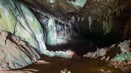 Dimly Lit Cave with Stalactites and Stalagmites