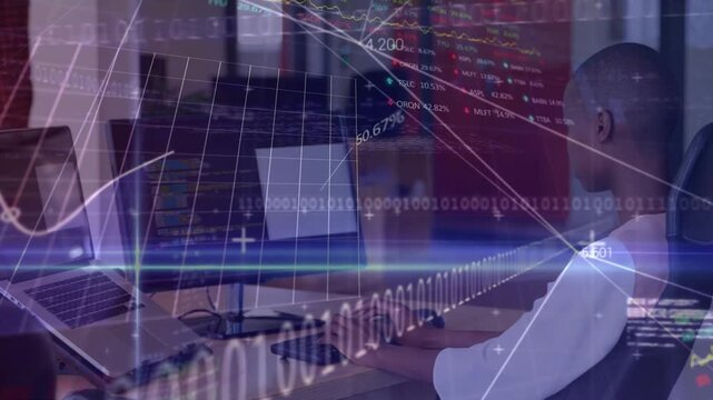 Man typing at workstation while overlay animations driving code and finance graphs for analysis