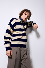 Fototapeta premium Stylish teenager poses confidently in trendy outfit against a simple backdrop