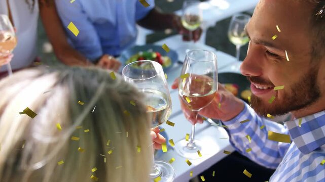 Woman raising glass, group clinking at long table, animated confetti falling celebrating dining