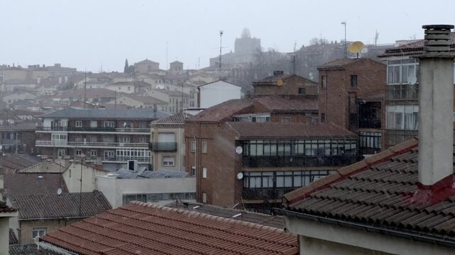 Heavy snow falls on a silent residential street in &Aacute;vila at night, covering pavements, parked cars and trees, while soft street lighting adds a peaceful, wintry atmosphere to the urban landscape.