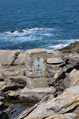 rocks in the sea with a marine anchor indication 