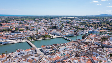 Obraz premium Tavira, a historic town in Algarve, Portugal, captured by a drone. You can see the buildings, Gilao river, and landscape on a sunny day