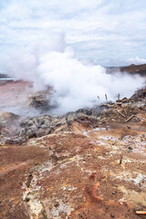 Gunnuhver active geothermal area with bubbling mud pools, fumaroles, hiking trails, and raised viewing platforms on the Reykjanes Peninsula during a day in March.