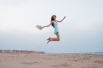Young woman enjoying freedom jumping on beach