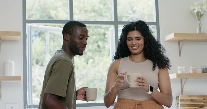 Couple African-American man offering mug to Indian woman, placing paper on tray at counter, reading