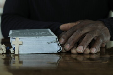 Obraz premium praying to god with hands showing his religious faith with God Caribbean man praying with background with people stock photo stock image