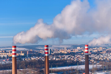 Large thermal power plant with cooling tower and smokestacks producing electricity for urban area, ideal for: energy industry, power generation, emissions, utilities, infrastructure, energy transition