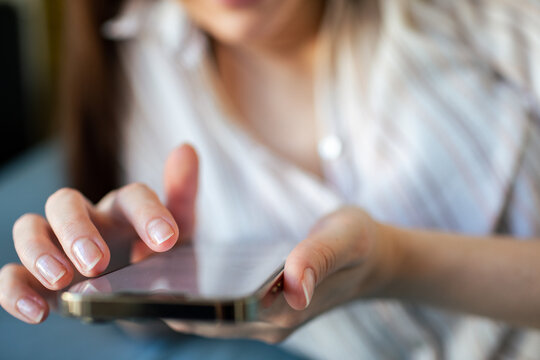Close-up of woman using smartphone at home
