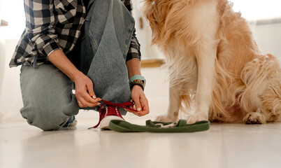 Girl Tying Shoelaces On Sneakers Before Walking Dog On Leash