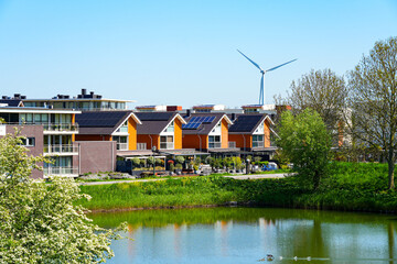 Obraz premium Modern sustainable neighborhood in Brielle with solar panels and wind turbine, South Holland, the Netherlands