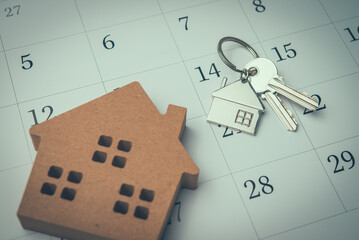 House and key on white calendar background. Mortgage loan for buying home or real estate property, home finance, money saving planning, money risk management, installment schedule and so on concept.