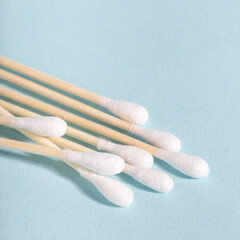 Cotton swabs with wooden sticks on blue background