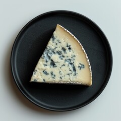 top down view of a black dinner plate with a slice of gorgonzola cheese