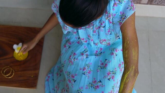 A woman applying homemade ubtan skincare mask on her arm and hands. Close up of Lady using natural cosmetic on body. Ayurvedic beauty treatment for clean skin. Ubtan paste massage at home.