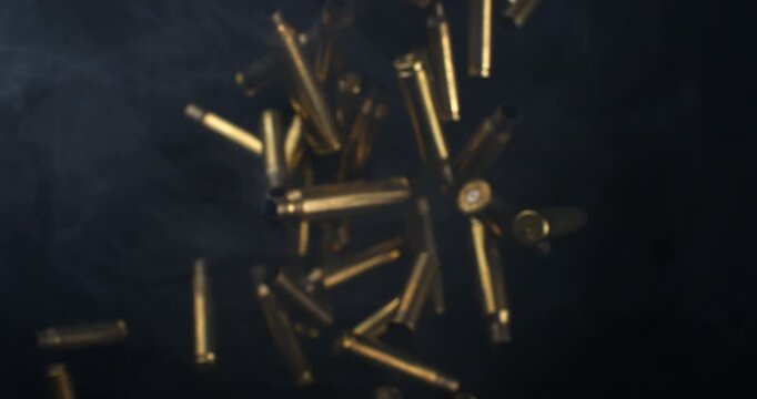 Slow Motion Macro Shot Of Brass Bullet Casings Burst On Black Background. Concept Of Ammunition, Industry And Impact