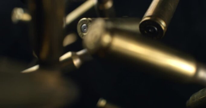Slow Motion Macro Shot Of Brass Bullet Casings Burst On Black Background. Concept Of Ammunition, Industry And Impact