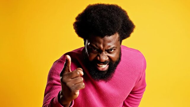 Angry man in pink sweater on yellow background