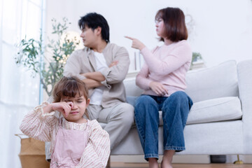 Little girl close her ears while her parent are having a fight in the livingroom