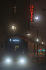 Ż&oacute;łty tramwaj we mgle, jadący ulicą Marszałkowska w Warszawie.