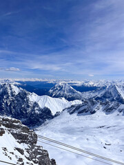 Zugspitze peak, the highest peak of Germany near Garmisch Partenkirchen. A view from Zugspitze mountain peak station. Snow landscape in April. Zugspitze Ski Resort. Winter in the Bavarian Alps. Hiking