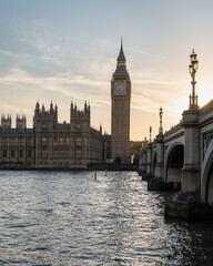 Fototapeta premium View of London's iconic Big Ben and the Palace of Westminster at sunset, with the Westminster Bridge stretching over the Thames