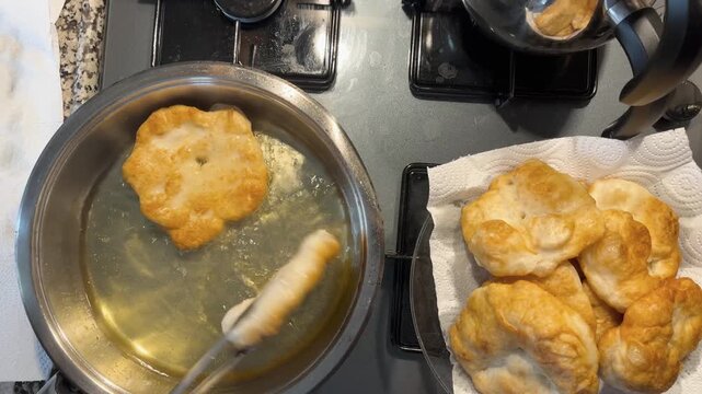 Golden-brown dough fritters (pişi) fried in hot oil.
