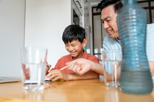 Father helping son with studies at home
