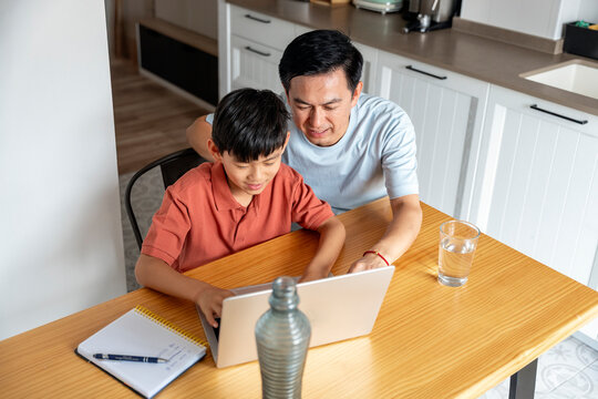 Chinese father and son using laptop together