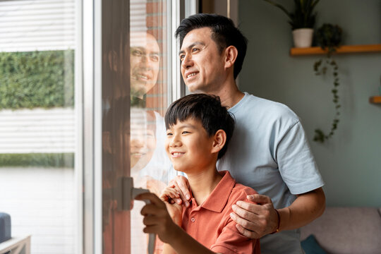 Father and son looking out the window together