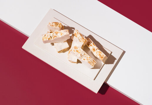 Nougat with almonds on a red background