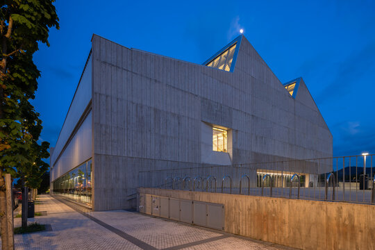 Brutalist sports complex exterior at dusk