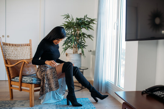 Young woman sitting stylishly in a chair indoors