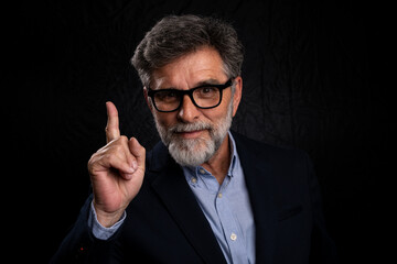 Obraz premium Senior businessman showing concept gesture, dramatic low key lighting