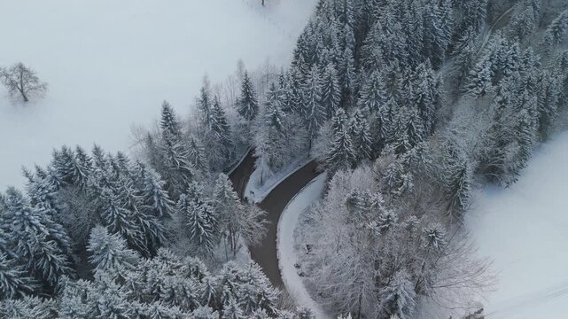 Snowy mountain road with cars driving through winter landscape