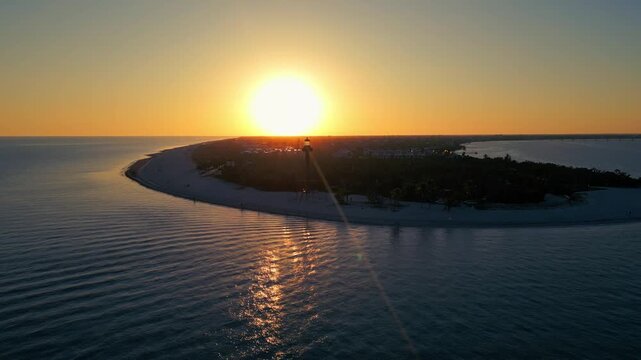 Sunset over Sanibel Island Florida with lighthouse, beach, and reflection on water 