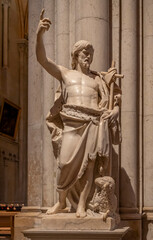Fototapeta premium Lyon, France - 10 23 2025: Cathedral and Primatial Church of Saint John the Baptist. A stone statue of Saint John the Baptist with a kneeling lamb