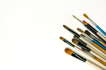 Fototapeta premium Various brushes lie on the right side on a white background