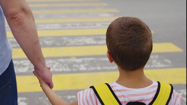 Education about traffic rules, Child&rsquo;s first day at school, Responsible adult on street, Safe city environment, Boy&rsquo;s journey to school, Parent holding child&rsquo;s hand, Teaching safety habits