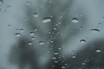 Abstraktes schwarz-wei&szlig; Motiv mit Wassertropfenmuster vor Wiesenh&uuml;gel mit B&auml;umen und Himmel mit Licht bei Sturm, Nebel, Frost und K&auml;lte am Morgen im Winter