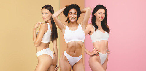 Three women stand in a studio with yellow and pink backgrounds. They strike poses while wearing simple white outfits. The setting highlights beauty and showcases different body types.