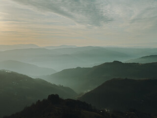 Obraz premium Layered mountain ridges in Serbia fading into mist. Soft light, atmospheric perspective and endless hills create a calm and minimalist natural background.