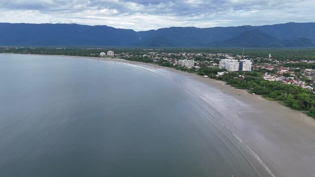 Vista a&eacute;rea da Praia do Indai&aacute; em Bertioga com mar, faixa de areia e bairro litor&acirc;neo ao fundo no litoral norte de S&atilde;o Paulo.