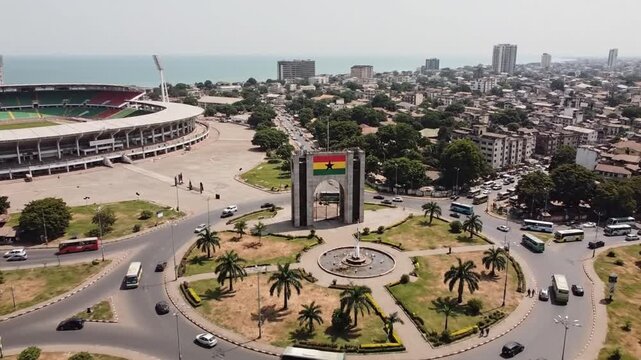 Aerial view of a busy city roundabout with a monument and buildings in Accra