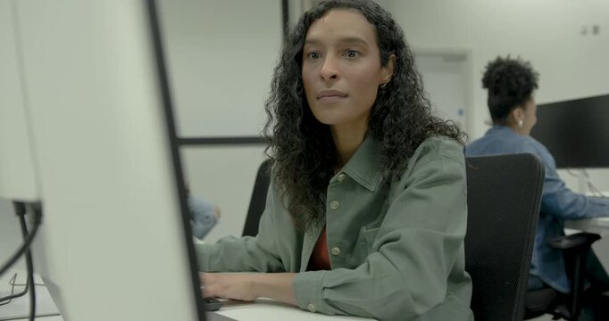 Portrait of a female coder in a modern tech workspace