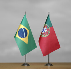 Table flags of Brazil and Portugal on gray blurred background