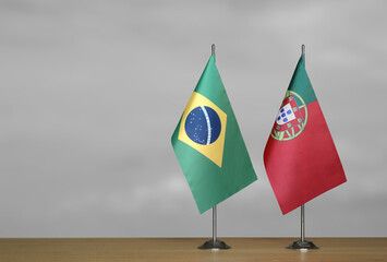 Table flags of Brazil and Portugal on gray blurred background