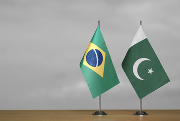 Table flags of Brazil and Pakistan on gray blurred background